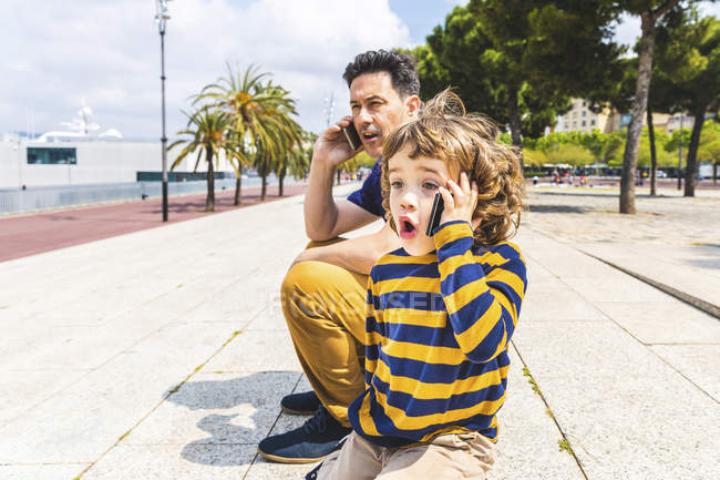 Spanien, Barcelona, Vater und Sohn beide mit Smartphone — Stockfoto