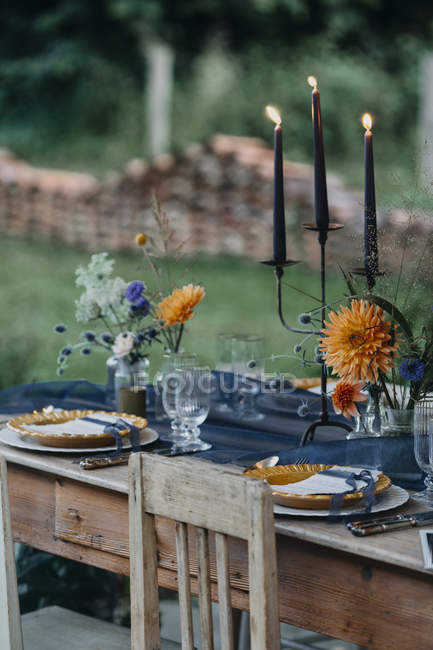 Tavolo festivo apparecchiato con candele all'aperto — Foto stock