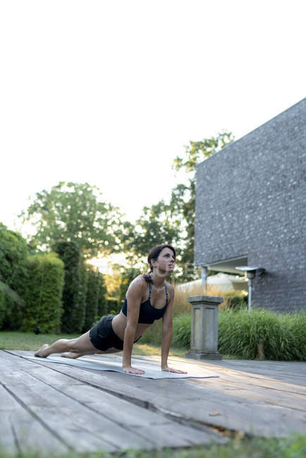 Donna che pratica yoga in giardino — Foto stock