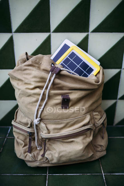 Cargador de panel solar y una tableta en una mochila - foto de stock