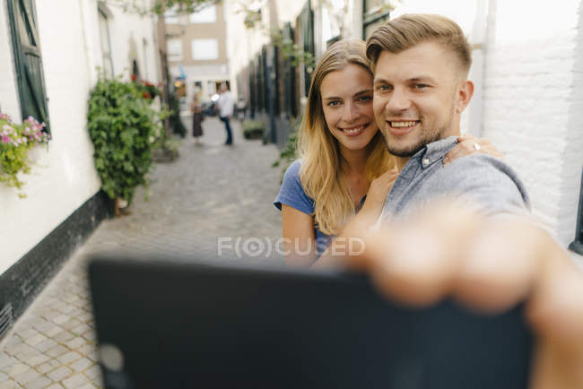 Paesi Bassi, Maastricht, felice giovane coppia che si fa un selfie in città con il cellulare — Foto stock