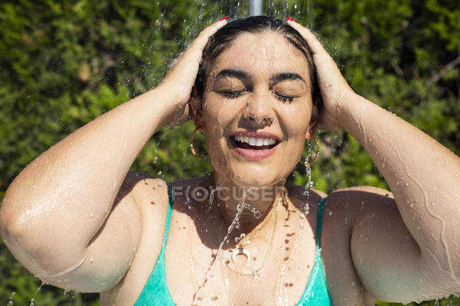 Retrato de una joven tomando una ducha al aire libre - foto de stock
