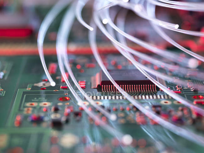 Fibra óptica atacando circuitos electrónicos con un virus - foto de stock