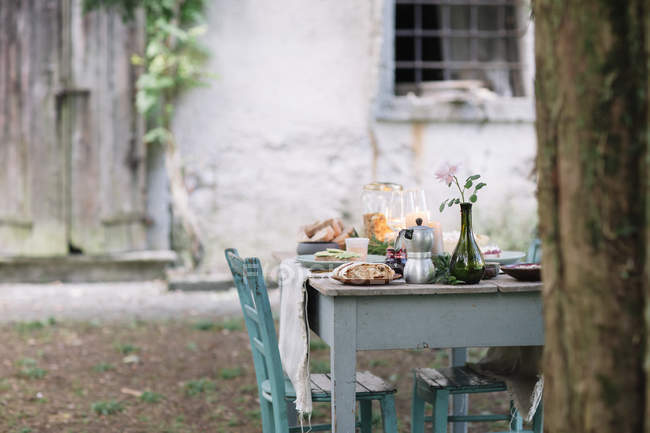 Laid garden table with candles next to a cottage — Stock Photo