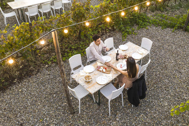 Itália, Toscana, Siena, jovem casal tendo um jantar romântico em uma vinha — Fotografia de Stock