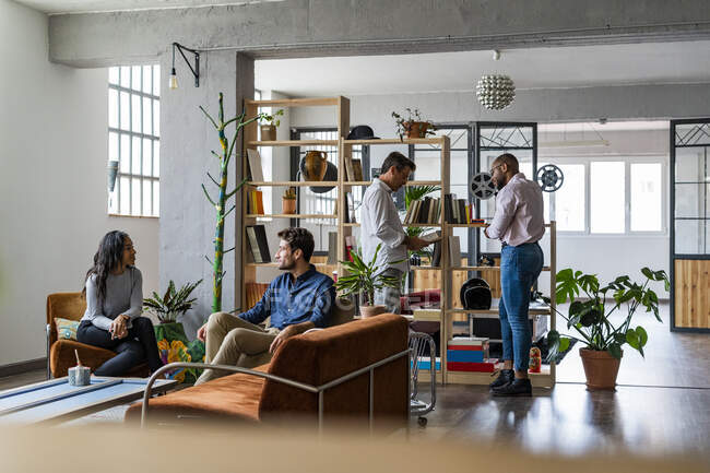 Équipe d'affaires ayant une réunion informelle dans un loft office — Photo de stock