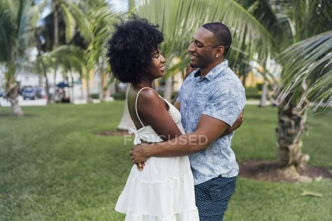 USA, Florida, Miami Beach, felice giovane coppia che si abbraccia in un parco in estate — Foto stock