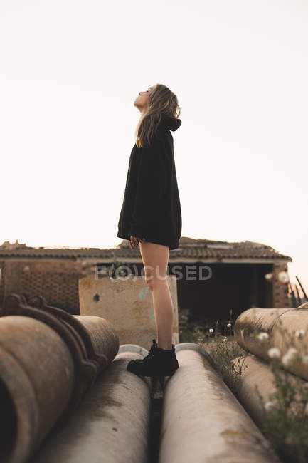Blonde woman standing on tubes, looking up — Stock Photo