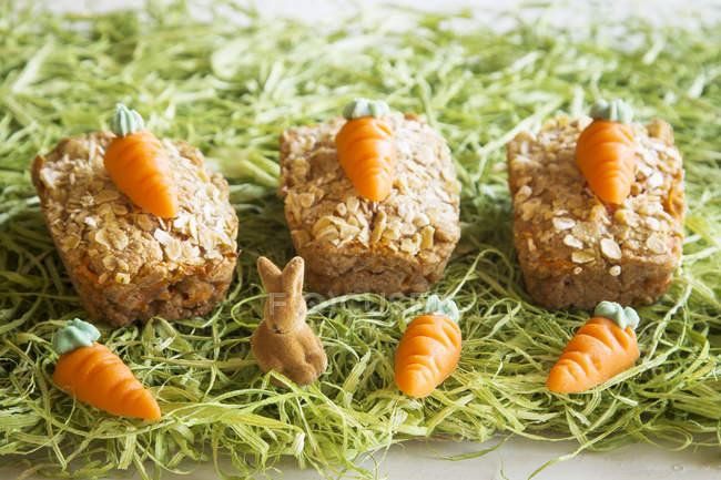 Trois mini gâteaux aux carottes avec des carottes de massepain et décoration de Pâques — Photo de stock