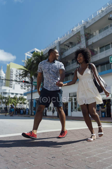 USA, Florida, Miami Beach, felice giovane coppia che attraversa la strada — Foto stock