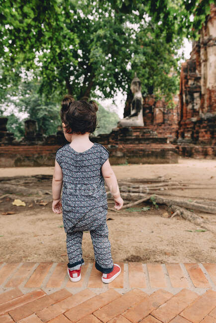Tailandia, Ayutthaya, Niña explorando el templo de Wat Mahathat - foto de stock