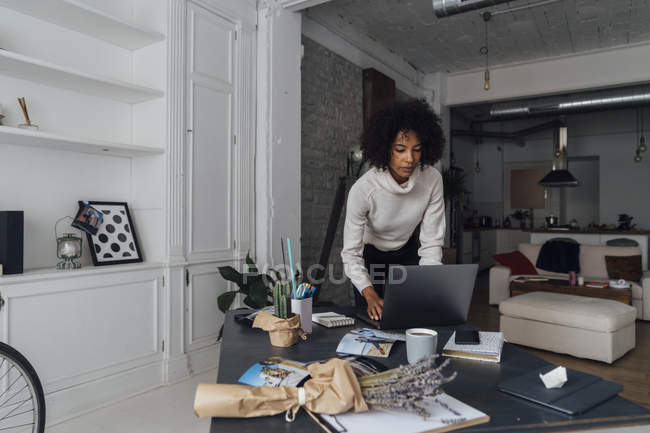 Женщина работает в своем домашнем офисе, используя ноутбук — стоковое фото