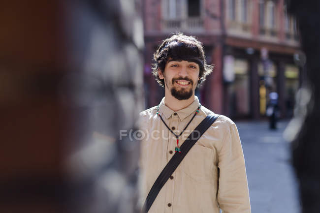 Portrait de jeune homme souriant dans la ville — Photo de stock
