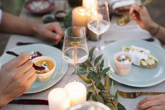 Крупный план пары, имеющей романтический ужин при свечах на открытом воздухе — стоковое фото