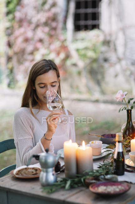 Bicchiere degustazione donna di vino al tavolo da giardino — Foto stock