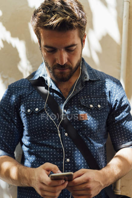 Geschäftsmann nutzt Kopfhörer und Smartphone im Freien — Stockfoto