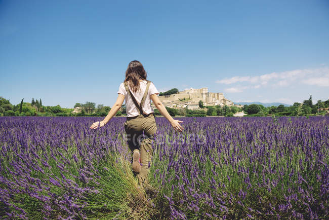 França, Grignan, vista traseira da mulher caminhando no campo de lavanda — Fotografia de Stock