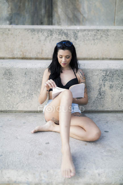 Portrait Of Tattooed Young Woman With Black Hair Reading A Book Hispanic Barefoot Stock Photo 274934510