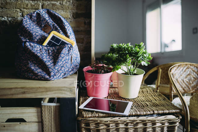 Cargador de panel solar en una mochila en casa y una tableta - foto de stock