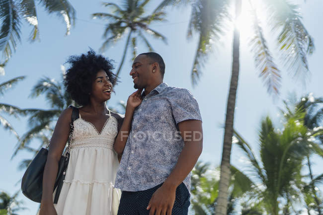 EUA, Flórida, Miami Beach, casal jovem feliz em palmeiras no verão — Fotografia de Stock