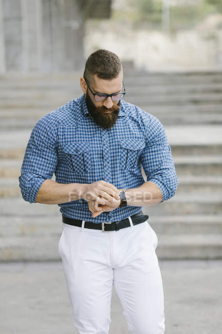 Bearded hipster businessman checking the time — Stock Photo
