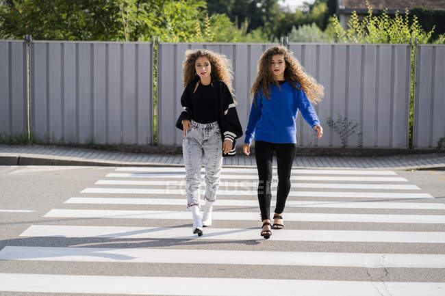 Jumeaux marchant sur le passage du zèbre — Photo de stock