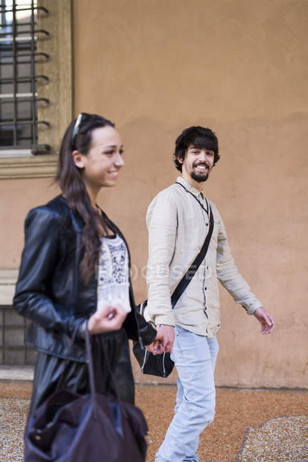 Retrato de jovem feliz andando de mãos dadas com sua namorada — Fotografia de Stock