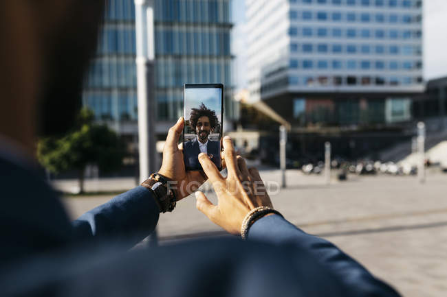 Espagne, Barcelone, plan rapproché d'un jeune homme d'affaires qui prend un selfie dans la ville — Photo de stock