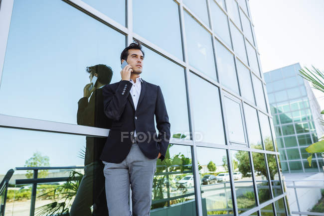 Homme d'affaires sur téléphone portable à l'extérieur du bâtiment de bureaux — Photo de stock