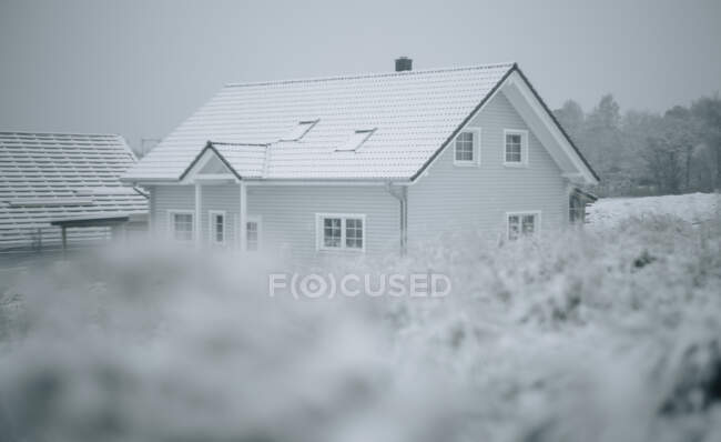 Erba e neve, casa cornice sullo sfondo — Foto stock