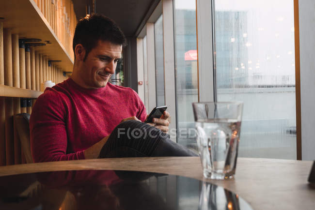 Uomo d'affari seduto nel ristorante, utilizzando il suo smartphone — Foto stock