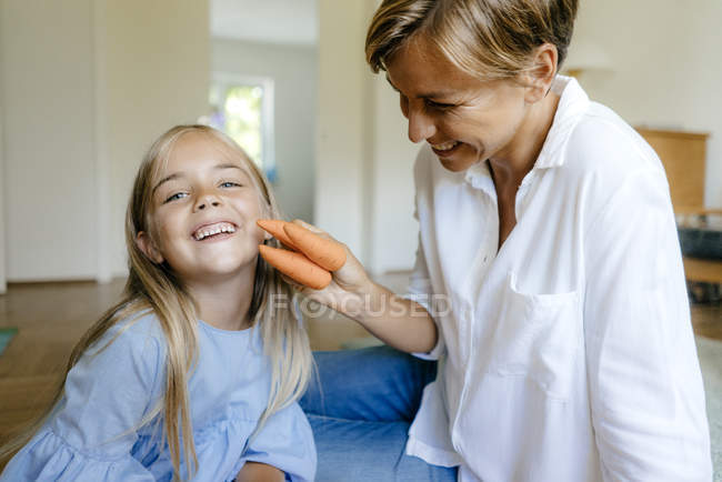 Felice madre e figlia con carote a casa — Foto stock