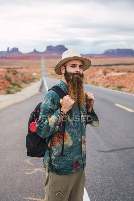 EUA, Utah, Homem com mochila em pé na estrada para Monument Valley — Fotografia de Stock