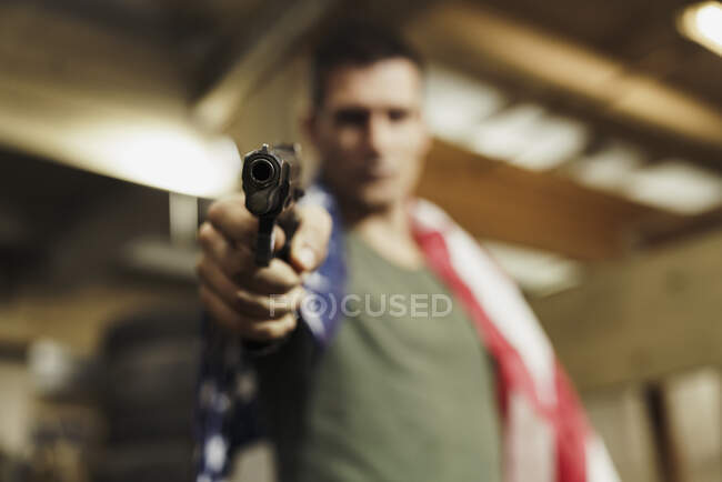 Close-up of man wearing American flag aiming with a gun — Stock Photo