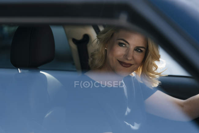 Sorrindo mulher no carro olhando para os lados — Fotografia de Stock