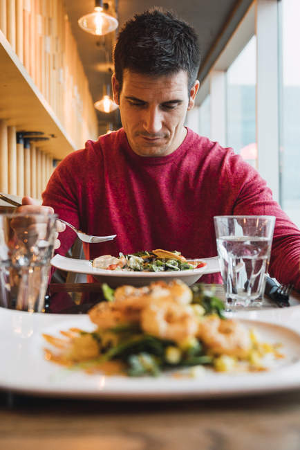 Empresario comiendo ensalada en un restaurante - foto de stock