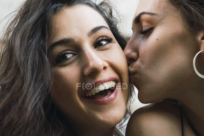 Mujer joven besando a su mejor amigo - foto de stock