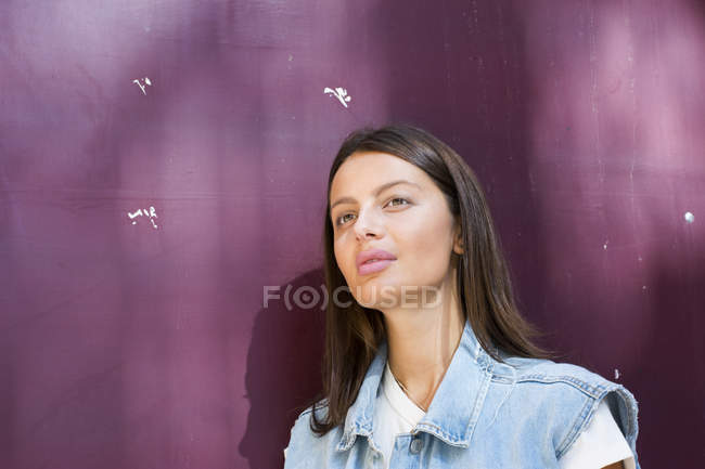 Портрет мечтающей молодой женщины на фиолетовом фоне — стоковое фото