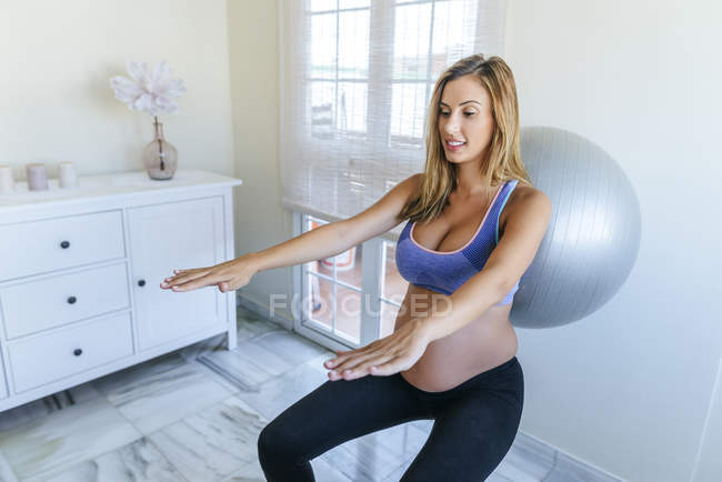 Donna incinta che pratica con palla fitness — Foto stock