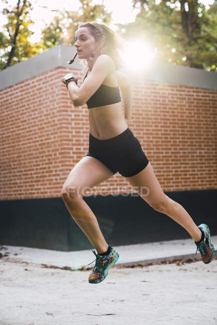 Fit young woman running an jumping in park — Stock Photo