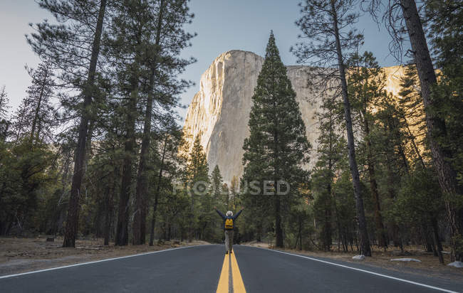 Usa, California, Yosemite National Park, uomo con armi sollevate su strada con El Capitan sullo sfondo — Foto stock
