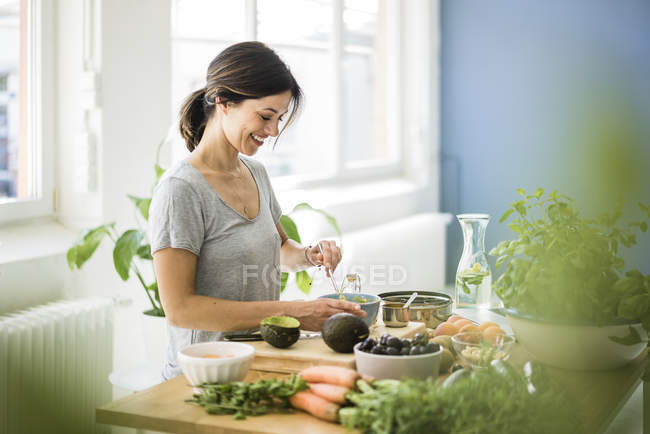 Woman preparing healthy food in her kitchen — Stock Photo