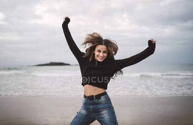 Портрет щасливої молодої жінки, що стрибає на берег. — стокове фото