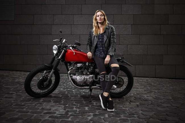 Портрет впевненої молодої жінки з мотоциклом — стокове фото