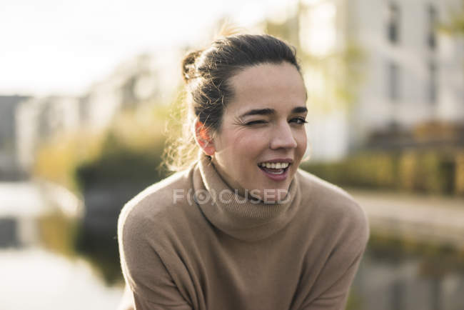 Portrait de femme clignante portant un pull à col roulé brun clair en automne — Photo de stock