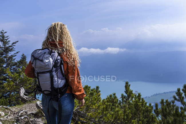 Mujer joven senderismo en las montañas de Baviera, mirando el lago Walchensee - foto de stock