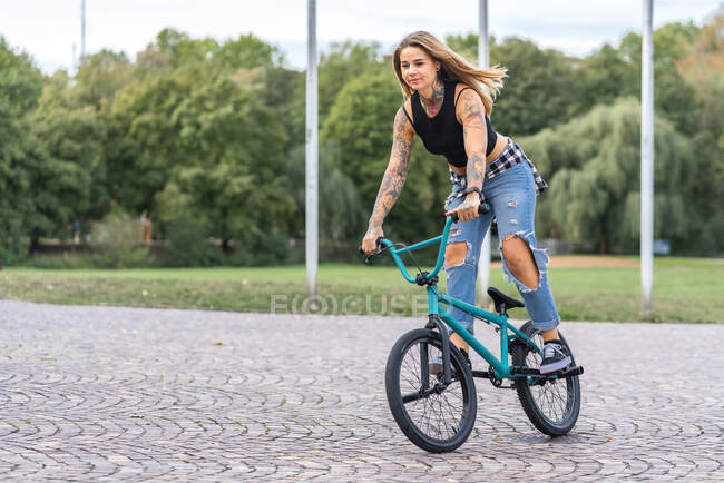 Giovane donna in sella alla sua bici BMX — Foto stock