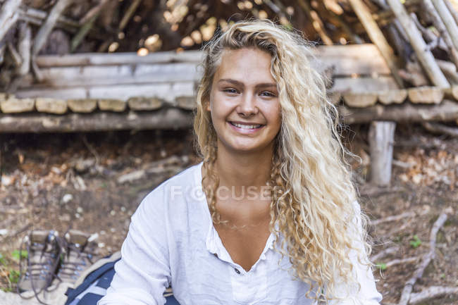 Портрет Усміхаючись молодої жінки в дерев'яному притулку — стокове фото
