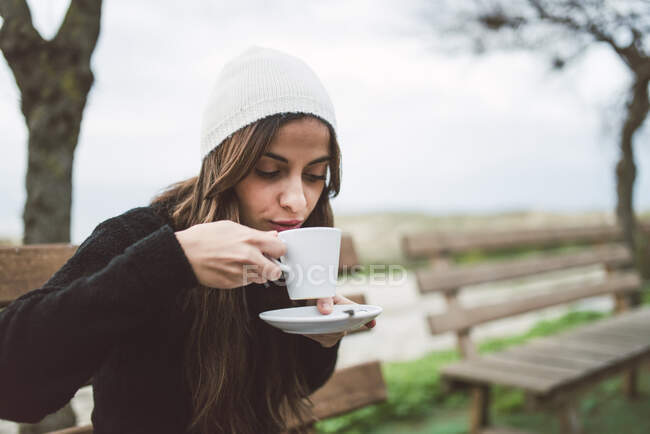 Ritratto di giovane donna che beve un caffè all'aperto — Foto stock