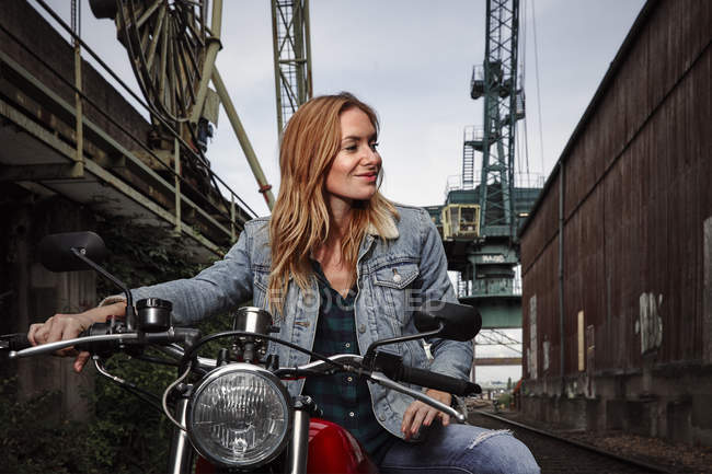 Portrait de jeune femme souriante sur moto — Photo de stock